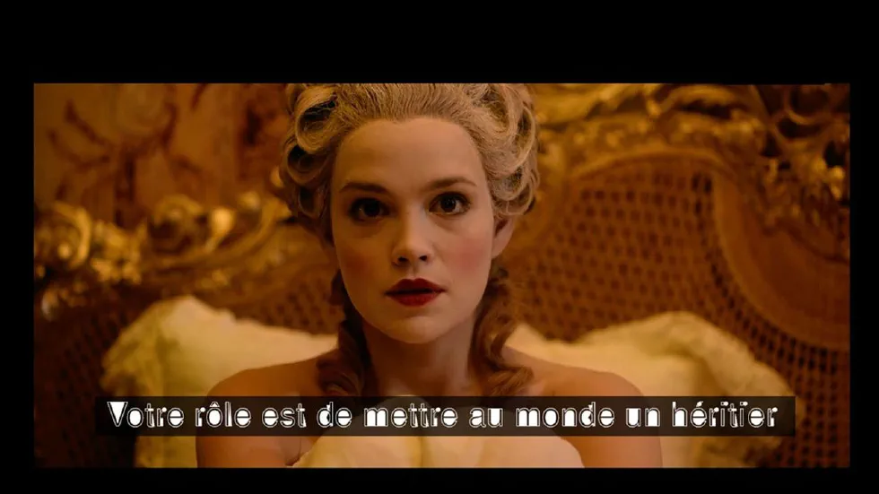 Une femme portant une perruque et un maquillage typiques du 18ème siècle regarde fixement l&rsquo;objectif. Le sous-titre avec une typographique particulière indique : « Votre rôle est de mettre au monde un héritier ».